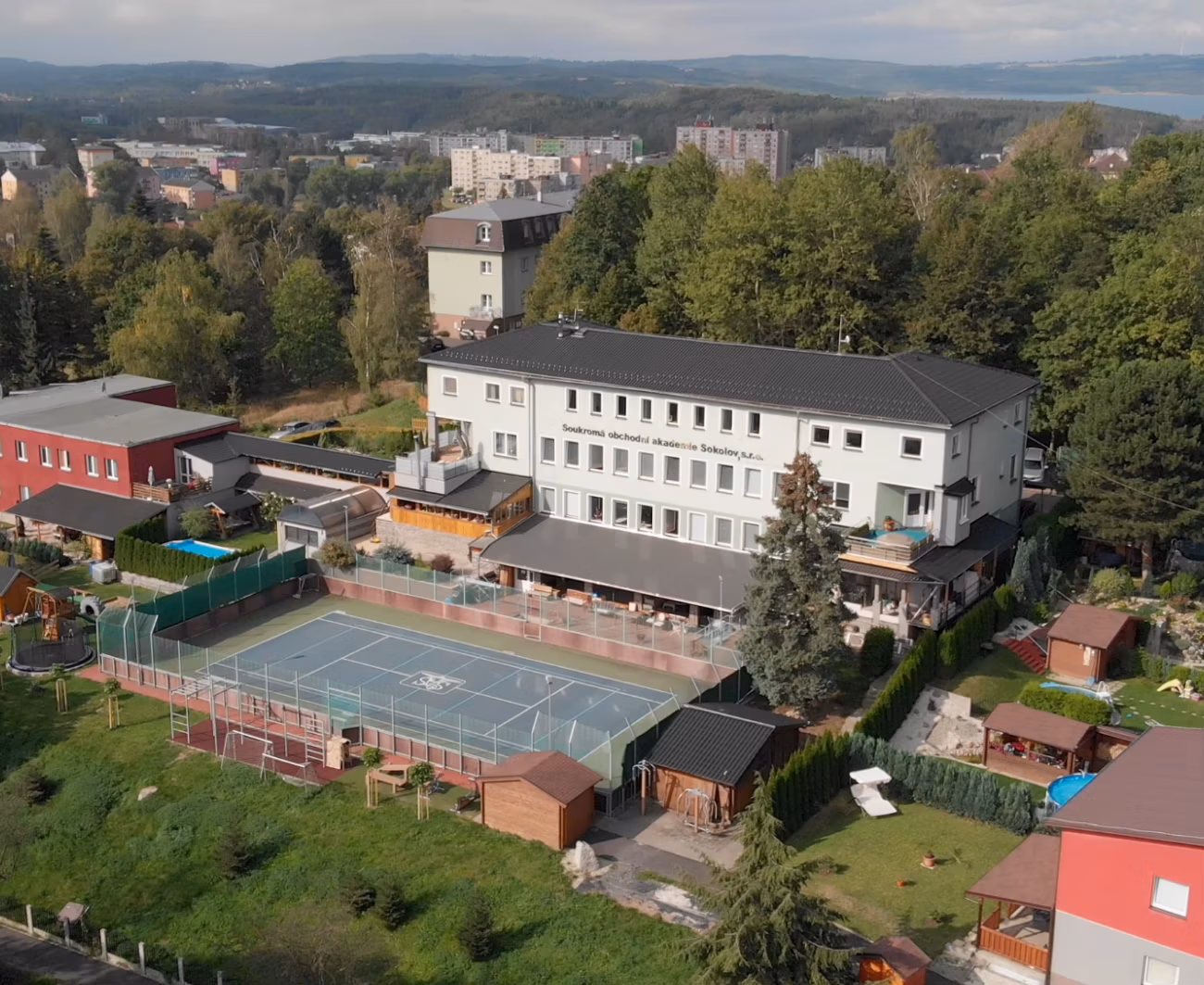 Budova Soukromé obchodní akademie Sokolov s vlastním hřištěm u parku Háječek